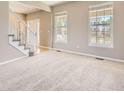 Bright living room with neutral carpet, fresh paint, and staircase at 11715 Crow Hill Dr, Parker, CO 80134