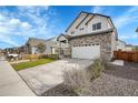 Charming home featuring a well-manicured lawn, stone accents and a long driveway at 10912 Memphis Ct, Commerce City, CO 80022