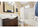 Cozy bathroom with a classic vanity, a bathtub and shower combination, and neutral tiling at 1331 Osceola St, Denver, CO 80204