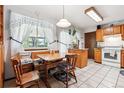 Eat-in kitchen features tile floor, wood cabinets, and a large window for natural light at 2516 S Cimarron St, Aurora, CO 80014