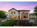 Home's exterior back view with a well-maintained deck, beautiful large windows, and stone accents at 6427 S Tibet St, Aurora, CO 80016