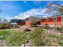 Large, sunny backyard with fire pit, lush plants and shrubs, and a mature shade tree at 6640 Grove St, Denver, CO 80221