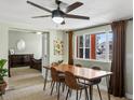 Bright dining area with wood floors, a modern ceiling fan, and large windows offering natural light and neighborhood views at 6640 Grove St, Denver, CO 80221