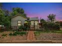 Twilight view of a single-story home with fence, walkway, and garden at dusk at 3625 W 9Th Ave, Denver, CO 80204