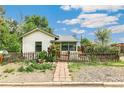 Inviting single-story home with a picket fence, walkway, garden, and lush landscaping at 3625 W 9Th Ave, Denver, CO 80204