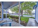Covered front porch features a seating area, manicured bushes, and a clear view of the peaceful neighborhood at 5455 W 112Th Pl, Westminster, CO 80020
