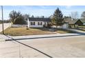 Well-maintained single-story home featuring a picket fence, a small front porch, and mature landscaping at 653 S Main St, Elizabeth, CO 80107