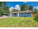 Charming blue single-story home with a well-manicured lawn and a one car garage with cars in the driveway at 1552 W Caley Ave, Littleton, CO 80120
