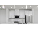Bright kitchen features white cabinets, stainless steel appliances and marble backsplash at 3109 Bates Ave, Denver, CO 80236
