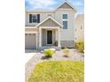 Inviting home exterior with stone accents, a covered porch, manicured lawn and well-kept landscaping at 7678 S Old Hammer Way, Aurora, CO 80016