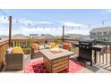 Inviting rooftop deck with a fire pit, grill, and comfortable seating for outdoor entertaining at 7678 S Old Hammer Way, Aurora, CO 80016