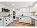 Beautiful modern kitchen with white cabinets, stainless steel appliances, granite countertops, and hardwood flooring at 7822 W Ottawa Pl, Littleton, CO 80128