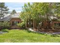 Charming brick home with a manicured lawn, mature trees, and a welcoming entrance at 120 Silver Leaf Way, Castle Rock, CO 80108