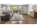 Cozy living room boasts lots of natural light, stylish decor, and sleek hardwood floors at 5995 Estes St, Arvada, CO 80004