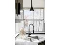 Close-up of a kitchen sink featuring stainless steel sink, modern fixtures and a bright window at 1566 S Richfield Way, Aurora, CO 80017
