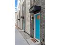 Townhome entrances showcasing modern design with gray brick, turquoise doors, and tidy landscaping at 1930 Hooker St # 3, Denver, CO 80204