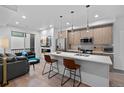 Open-concept kitchen featuring an island with seating, stainless appliances, and modern pendant lighting at 1930 Hooker St # 3, Denver, CO 80204