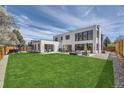 Modern home features a spacious lawn, outdoor seating, and large windows offering great views at 3083 S Garfield St, Denver, CO 80210