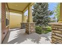 Covered porch with decorative stone supports adding character and curb appeal to the home at 1562 Suncrest Rd, Castle Rock, CO 80104