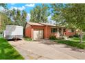 Quaint brick home with an attached garage, a well-kept lawn, and inviting curb appeal, perfect for comfortable living at 6371 Brooks Dr, Arvada, CO 80004