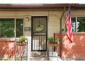Charming porch featuring a decorative wreath, potted plants, and an American flag creating a warm, welcoming entrance at 6371 Brooks Dr, Arvada, CO 80004