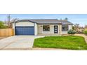 Charming single-story home featuring a well-manicured lawn, a blue two-car garage, and a welcoming front entrance at 2484 E 101St Ct, Thornton, CO 80229