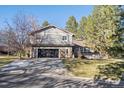 Gray shingle two-story house with a black garage door and landscaped yard at 6269 S Coventry E Ln, Littleton, CO 80123