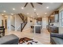 Bright and open-concept living space featuring hardwood floors, modern staircase and kitchen island at 5392 Sanctuary Ave, Firestone, CO 80504