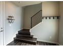 Inviting entryway features dark wood stairs, coat rack and decorative shelving for a modern aesthetic at 15858 E Broncos Pl, Englewood, CO 80112