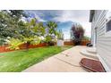 Spacious backyard featuring lush lawn, mature trees, a shed, and a concrete patio perfect for outdoor entertainment at 2160 Ance St, Strasburg, CO 80136