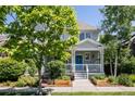 Beautiful two-story home featuring a welcoming front porch, complemented by lush landscaping and mature trees at 10069 E 28Th Ave, Denver, CO 80238