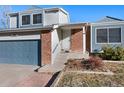 Welcoming entrance to home featuring brick accents, a storm door, and freshly landscaped garden at 19697 E Flora Pl, Aurora, CO 80013