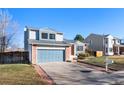 Attractive home with a blue garage door, brick siding, and a lush front yard in a Gathering-friendly neighborhood at 19697 E Flora Pl, Aurora, CO 80013