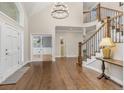 Elegant foyer featuring hardwood floors, a grand staircase with iron spindles, and a modern chandelier at 2555 S Zang St, Denver, CO 80228
