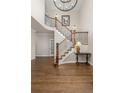 Inviting foyer with hardwood floors, elegant staircase with iron spindles, and a decorative table at 2555 S Zang St, Denver, CO 80228