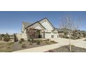 Charming two-story home featuring a three-car garage, stone accents, and landscaped front yard at 21701 E 50Th Dr, Aurora, CO 80019
