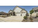 Charming two-story home featuring a three-car garage, stone accents, and landscaped front yard at 21701 E 50Th Dr, Aurora, CO 80019
