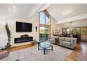 Bright and airy living room with a fireplace, large windows, wood floors, and access to the balcony at 4520 Forest Hill Rd, Evergreen, CO 80439