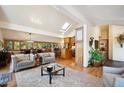 Open-concept living room with a skylight, wood floors, cozy seating, and seamless flow to the dining area at 4520 Forest Hill Rd, Evergreen, CO 80439