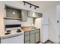 Compact kitchen featuring white appliances, olive colored cabinets, and wood-look countertops at 1265 Colorado Blvd # 12, Denver, CO 80206