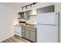 Efficient kitchen space with a white refrigerator and stove, complemented by neutral toned cabinets and wood counters at 1265 Colorado Blvd # 12, Denver, CO 80206