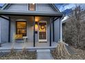 Inviting front porch with bench seating, wreath on the door, and black support columns at 1181 S Clarkson St, Denver, CO 80210