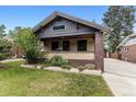 Inviting home featuring a front porch, well-manicured lawn, and brick accents at 3145 W 31St Ave, Denver, CO 80211