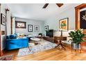 Bright living room with a comfortable blue sofa, stylish decor, and hardwood floors at 3145 W 31St Ave, Denver, CO 80211