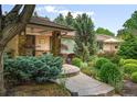 Inviting front entrance with stone accents, a concrete walkway, and a manicured garden at 3401 E Kentucky Ave, Denver, CO 80209
