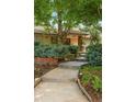 Front entrance with stone accents, a concrete walkway, and lush landscaping at 3401 E Kentucky Ave, Denver, CO 80209