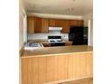 The kitchen features wood cabinets, black appliances, and an island at 11318 Clermont Dr, Thornton, CO 80233