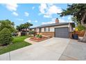 Front view of a ranch home with a gray garage door and landscaped yard at 1586 S Field Ct, Lakewood, CO 80232