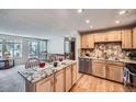 The kitchen features hardwood floors, stainless steel appliances, and a granite countertop island at 2695 S Ames Way # 1, Lakewood, CO 80227