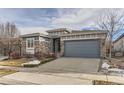 Ranch style home with gray siding, stone accents, and a two-car garage at 12432 Meadowlark Ln, Broomfield, CO 80021